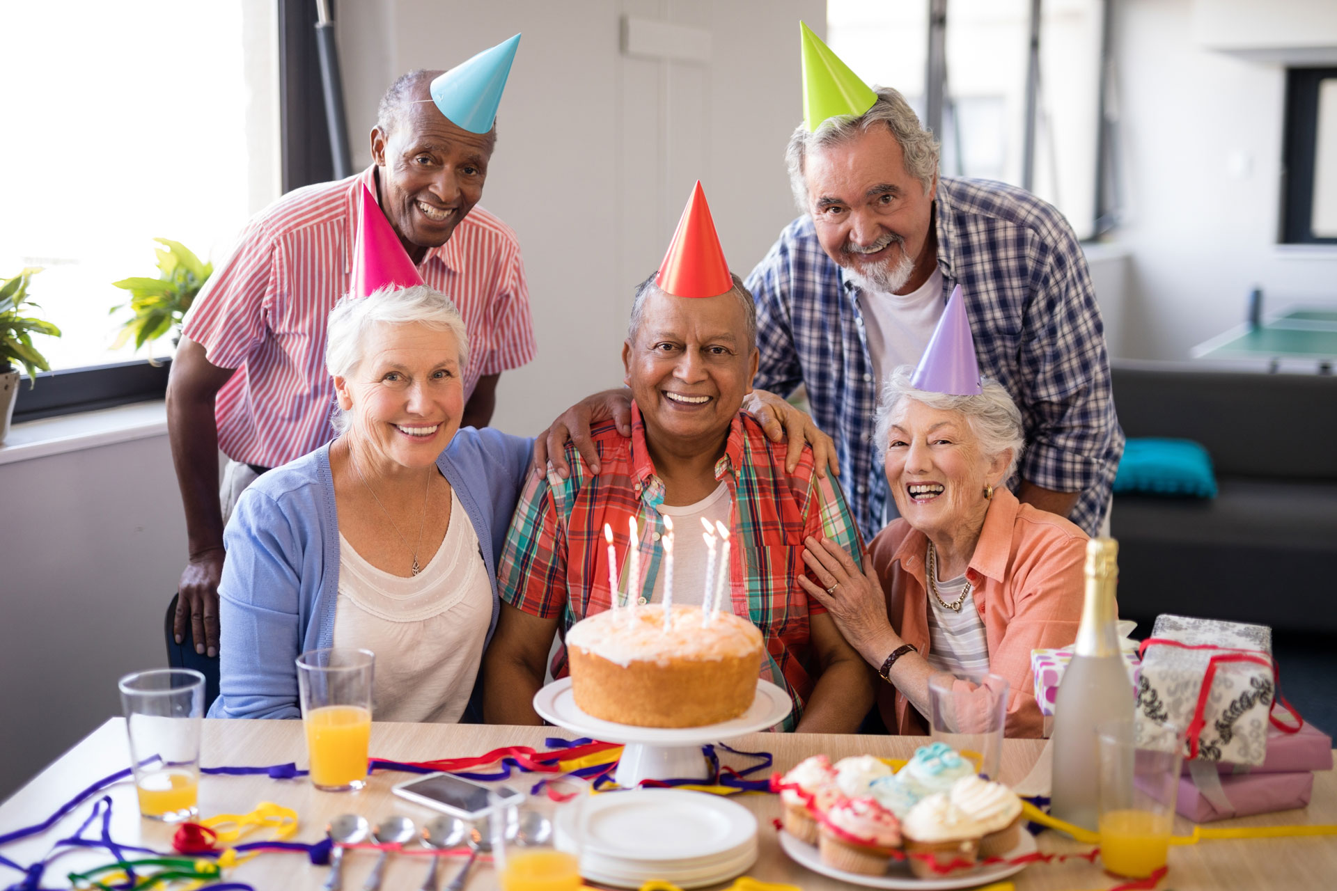 residents with birthday hats and delectable treats--cakes and cupcakes