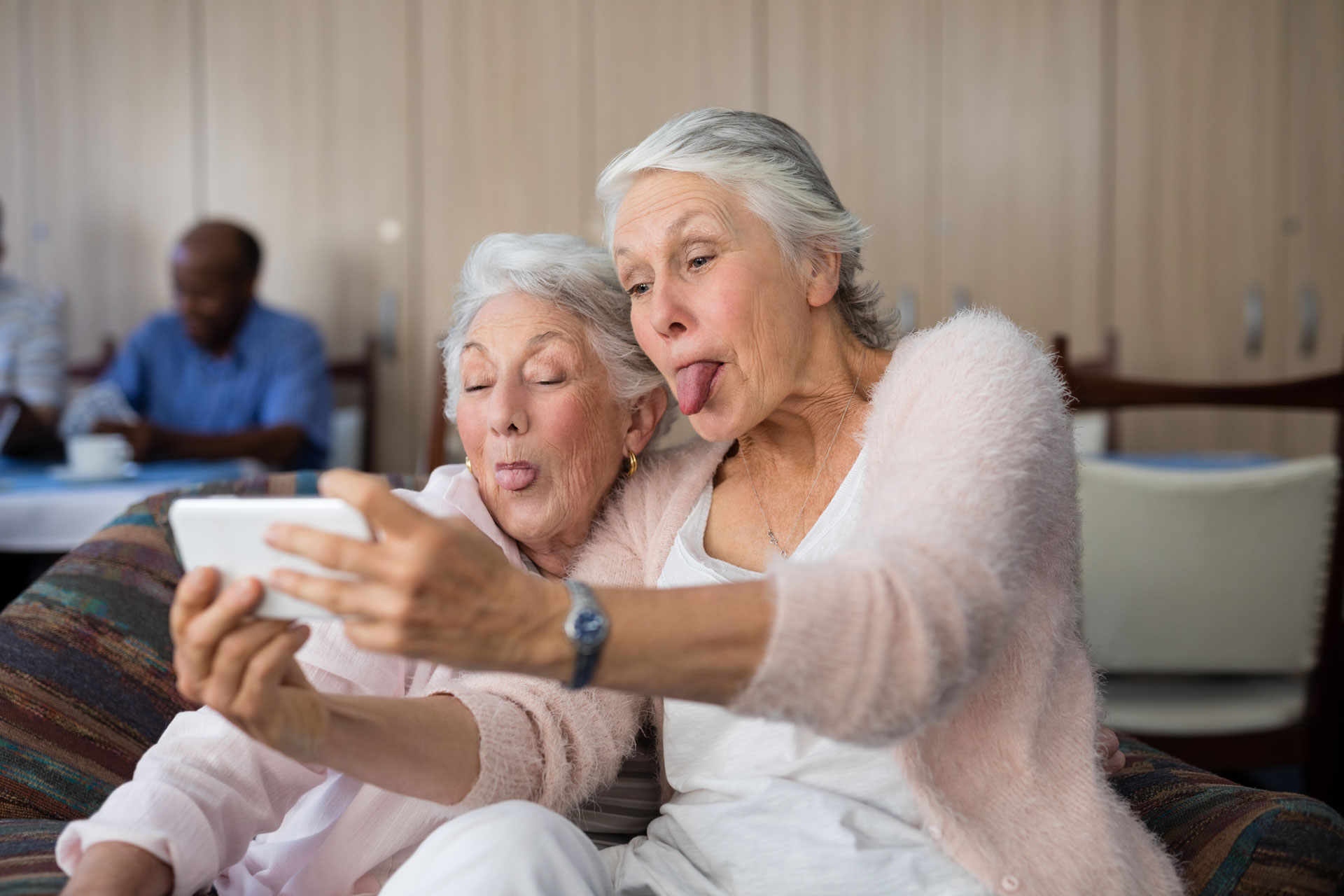 Brentwood_Short_Term_Respite_175837702_web Two senior women taking a selfie and making silly faces together.